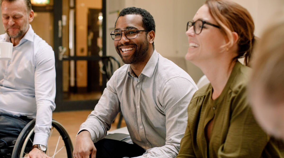 Colleagues sitting around a table laughing 